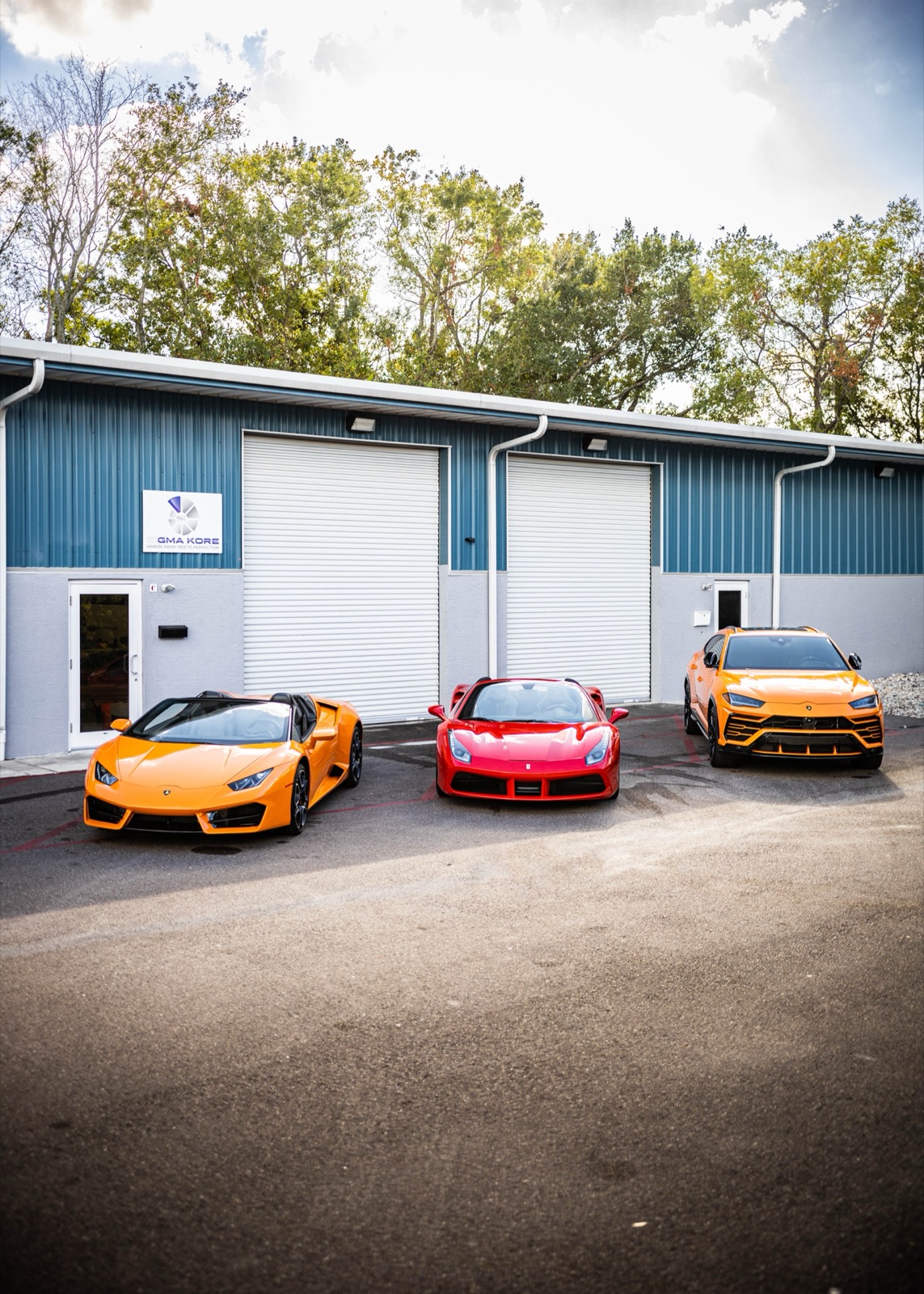 Huracan, Ferrari 488, and Urus lined up outside a detail shop